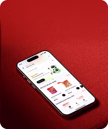 Smartphone displaying a grocery shopping app open on a red textured surface.