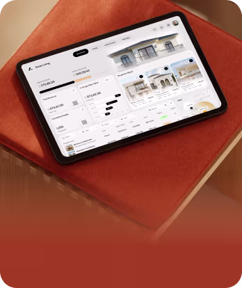 Tablet on orange fabric showing a real estate app with property listings and prices.